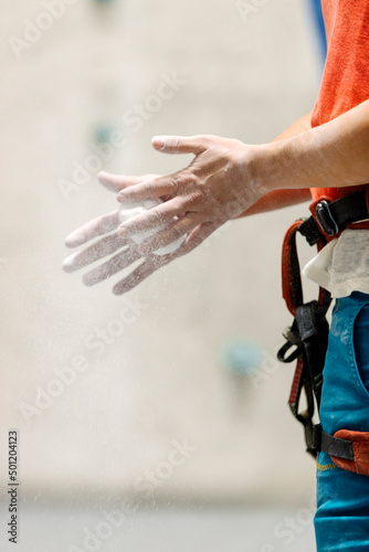 Rock climber chalking her hands.