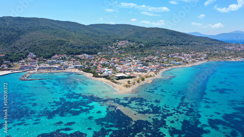 Aerial drone photo of iconic picturesque village, main port and beautiful turquoise beaches of Skala featuring landmark church of Agioi Anargiroi, Agistri island, Saronic gulf, Greece photo