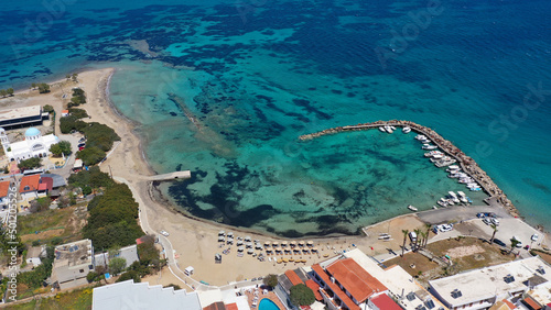 Aerial drone photo of iconic picturesque village, main port and beautiful turquoise beaches of Skala featuring landmark church of Agioi Anargiroi, Agistri island, Saronic gulf, Greece photo