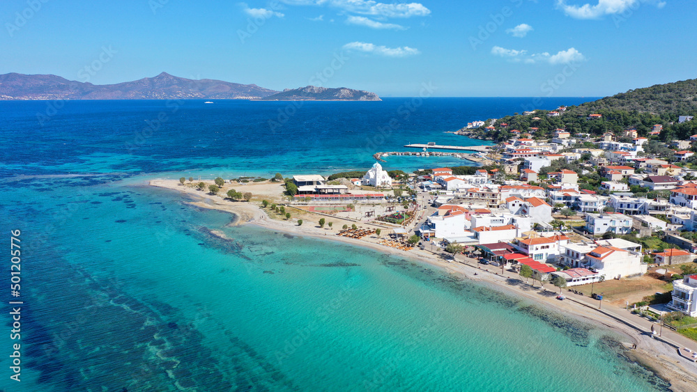 Aerial drone photo of iconic picturesque village, main port and beautiful turquoise beaches of Skala featuring landmark church of Agioi Anargiroi, Agistri island, Saronic gulf, Greece