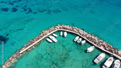 Aerial drone photo of tropical exotic paradise island bay with deep turquoise sea forming a blue lagoon visited by luxury yachts and sail boats