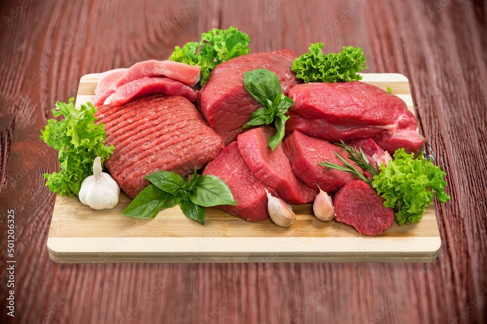 Fresh raw meat on board with ingredients for marinated