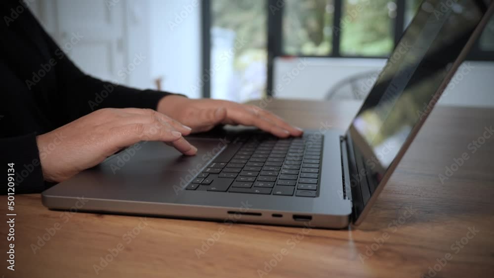 Femme qui travaille sur un ordinateur portable. Gros plan sur les mains et le clavier. Plan en travelling lent. Vidéo 4K
