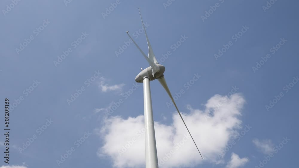 Éolienne en fonctionnement sur un fond de ciel bleu ensoleillé. la silhouette de l'éolienne se détache. vidéo 4K Éolienne en fonctionnement sur un fond de ciel bleu ensoleillé. la silhouette de l'éolienne se détache. vidéo 4K