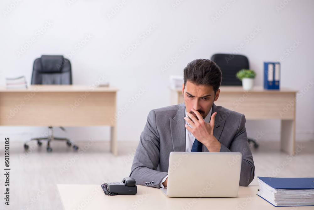 Young male employee working in the office Young male employee working in the office