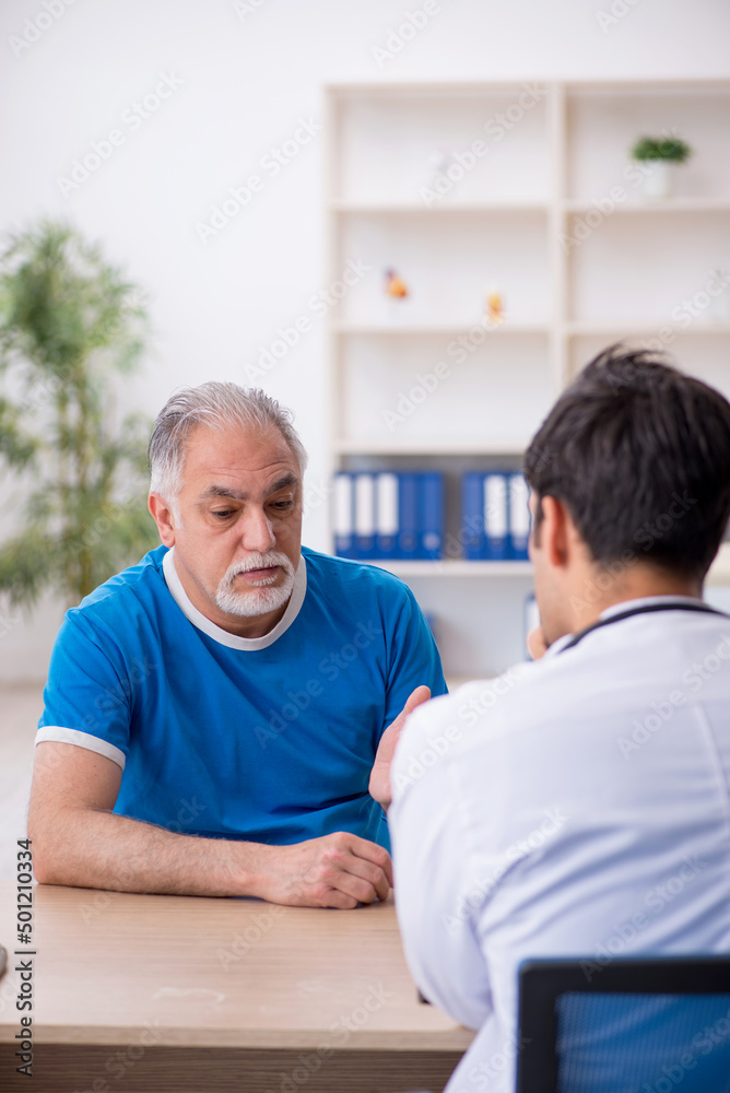 Old male patient visiting young male doctor Old male patient visiting young male doctor