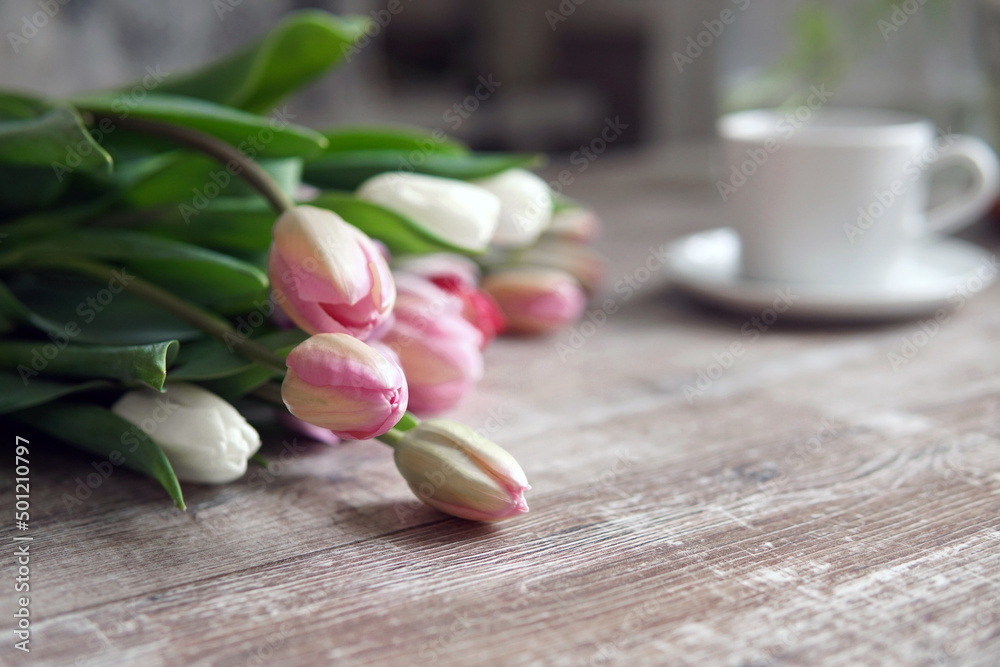 Bouquet of tulips and a cup of coffee on the table. Morning Bouquet of tulips and a cup of coffee on the table. Morning