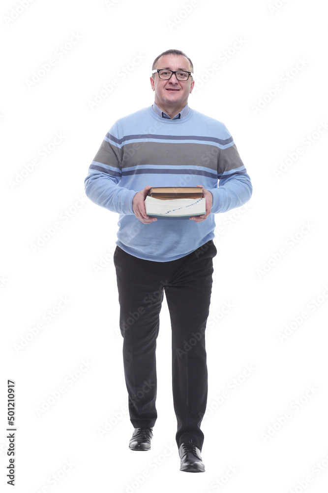 in full growth. confident man with books walking towards you in full growth. confident man with books walking towards you