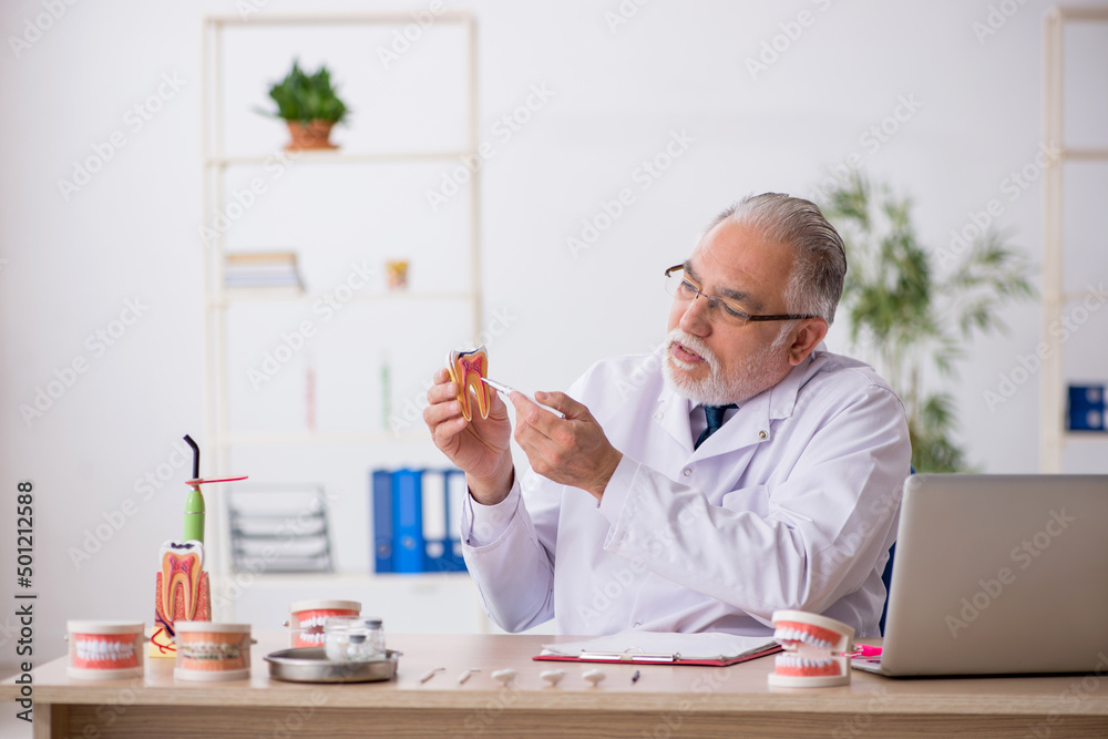 Old male doctor dentist working in the clinic Old male doctor dentist working in the clinic