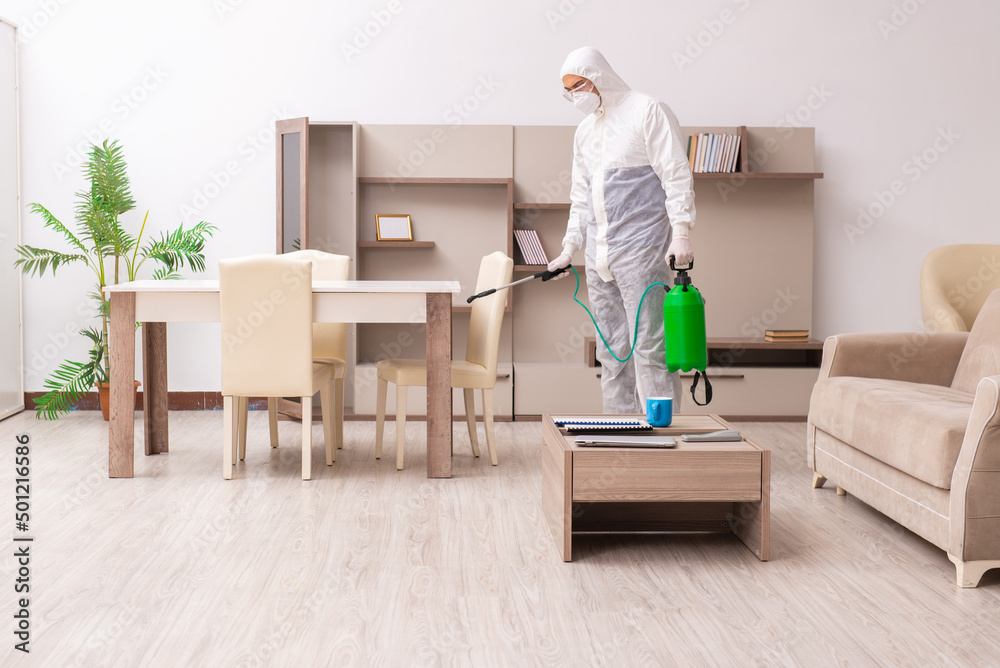Young male contractor doing pest control at home Young male contractor doing pest control at home