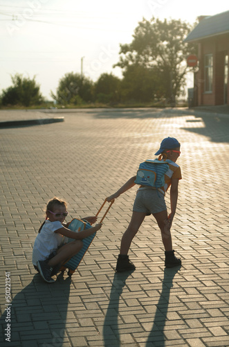 Kids with suitbag outdoors photo