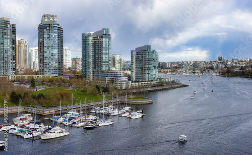 Aerial View of Vancouver Downtown City in False Creek, British Columbia, Canada. Sunny Cloudy Day. Modern Cityscape, residential homes, buildings, boats and marina.