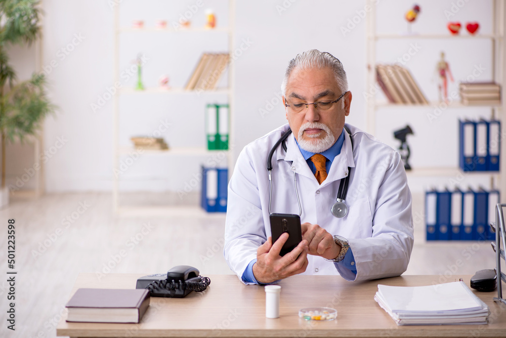 Old male doctor working in the clinic