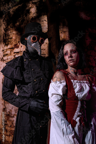 Black plague doctor with a nearly dead medieval lady