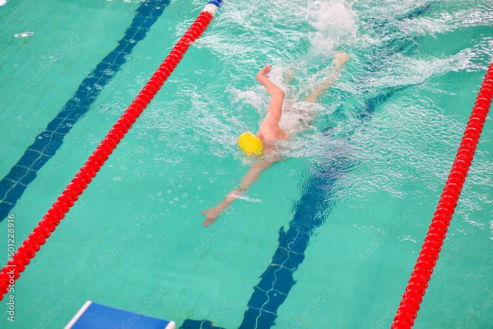 The swimmer swims in the pool. Participation in the competition. Sport, health and active life.