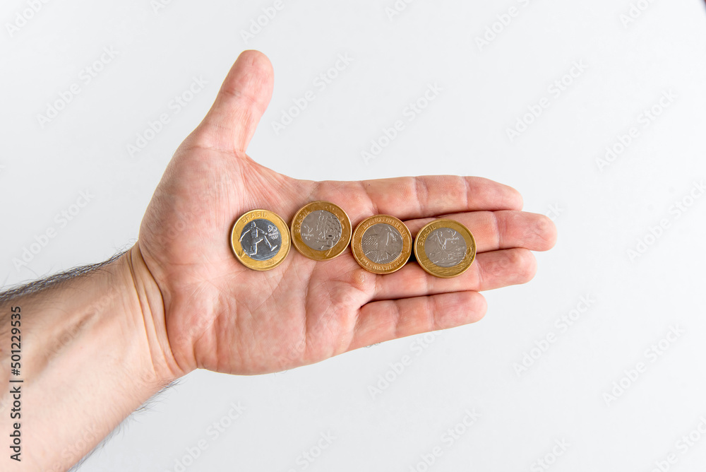 Fototapeta premium Hand holding Brazilian commemorative coins, Brazilian real coins.