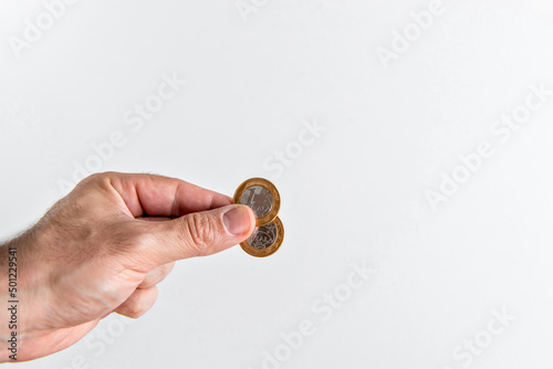 Hand holding two 1 Brazilian Real coins, Brazilian Real coins. photo