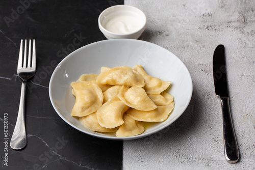 Traditional ukrainian dish vareniki served in a bowl with sour cream. Close up view of traditional Ukrainian food.