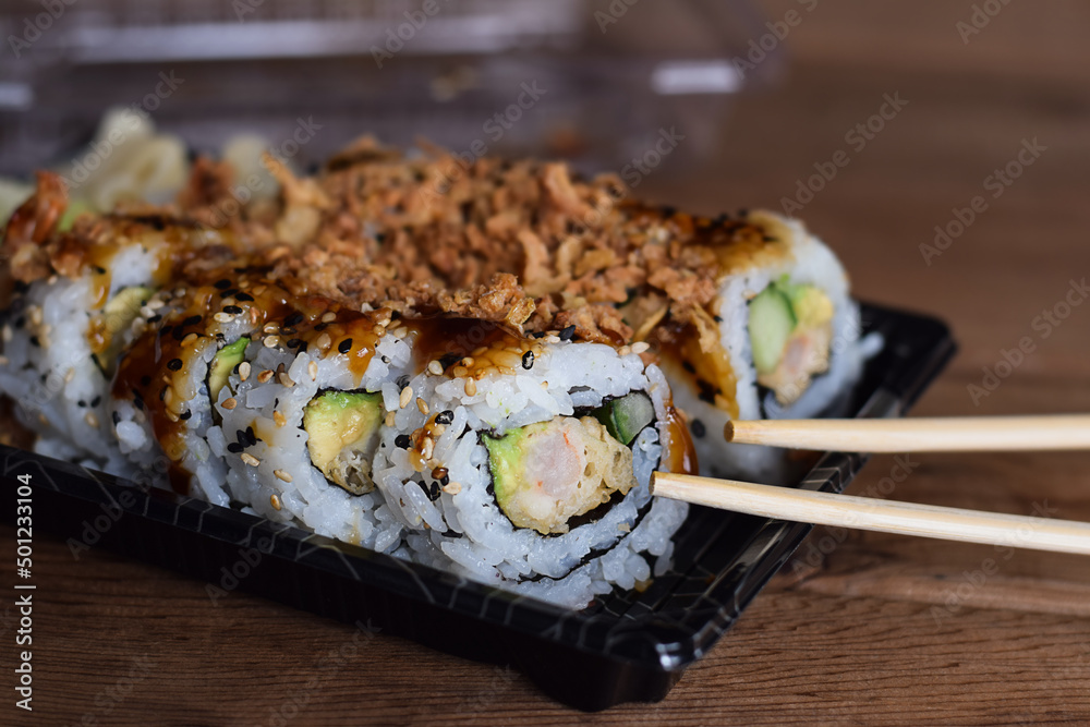 Take out container with crispy dragon roll sushi Take out container with crispy dragon roll sushi