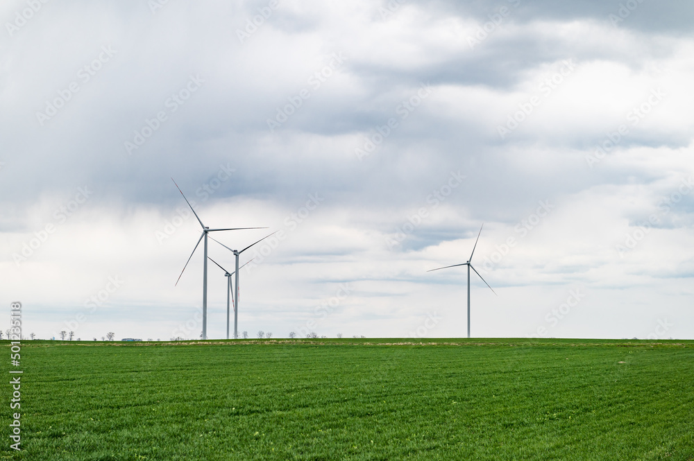 Eco banner or header image of three wind turbines of a wind farm, producing renewable energy. Clean green alternative power. Wind energy to fight climate change and global warming. Eco banner or header image of three wind turbines of a wind farm, producing renewable energy. Clean green alternative power. Wind energy to fight climate change and global warming.