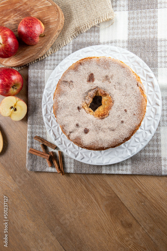 Sponge cake or chiffon cake with apples so soft and delicious sliced ​​with ingredients: cinnamon, eggs, flour, apples on wooden table. Home bakery concept for background and wallpaper. Top view.