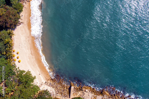 Guaruja. Aerial view of sunny tropical beach with turquoise waves crashing on white sand. Praia do Éden (Eden’s Beach), Guarujá, Brazil. Small beach with jungle-like surroundings. photo