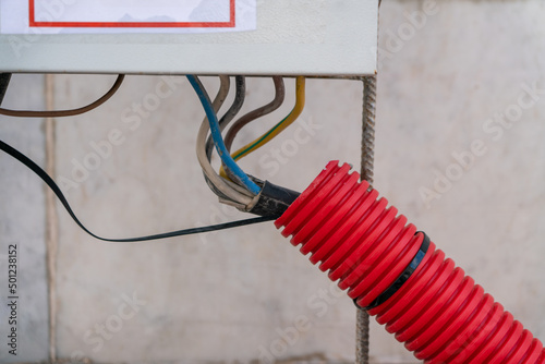 The wires in the outdoor protective corrugation stretch to the electrical panel.