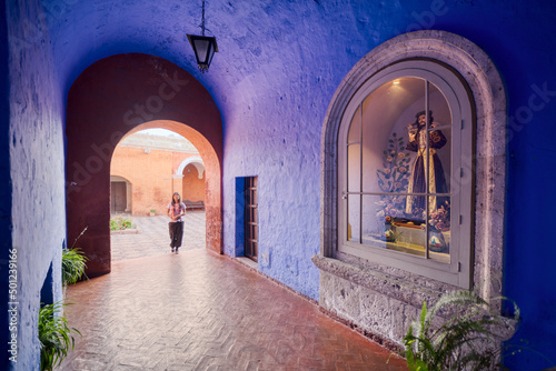 Turista latina entrando al claustro de los naranjos del monasterio Santa Catalina en Arequipa photo