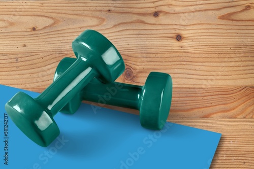 Healthcare and home exercises concepts. Fitness dumbbell and roller on the floor in the gym.