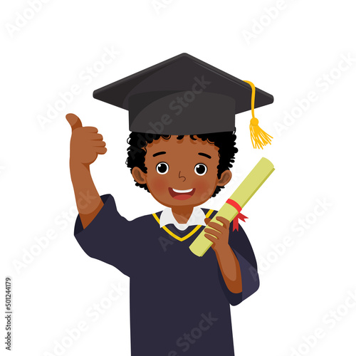 cute little African schoolboy in graduation hat and gown holding diploma certificate showing thumb up