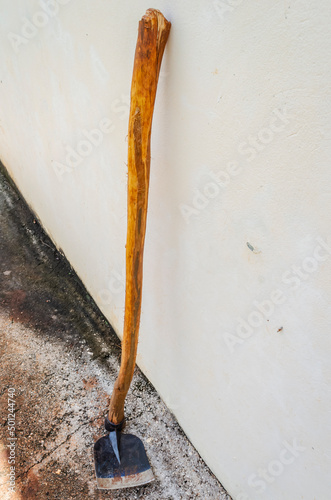 Black Hoe With Long Stick Leaning Against A Wall