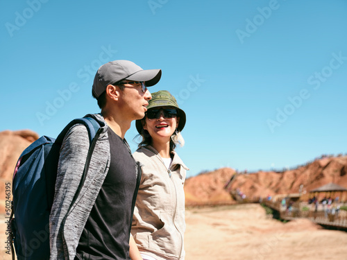 asian couple walking in national park with yardang landforms © imtmphoto