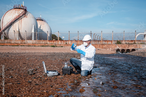 Scientist wearing protective uniform and glove under working water analysis and water quality by get fishes dead to check effected case in laboratory is environment pollution problem concept.