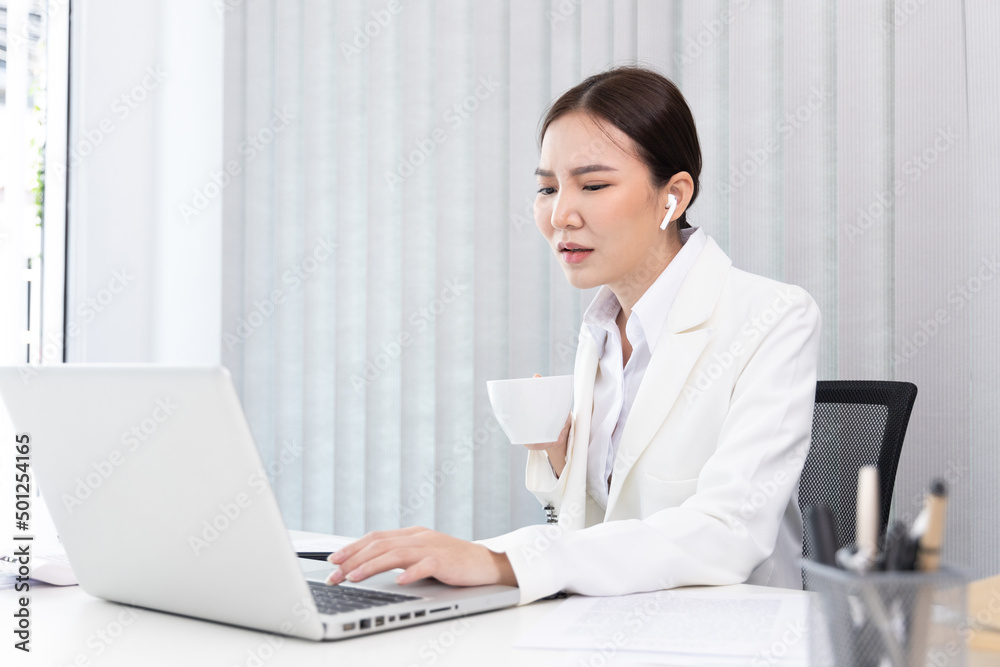 Businesswoman's hand presses on a laptop keyboard and holding a cup of hot coffee, Sitting in a private office, Using computers to conduct financial transactions, World of technology and internet... Businesswoman's hand presses on a laptop keyboard and holding a cup of hot coffee, Sitting in a private office, Using computers to conduct financial transactions, World of technology and internet...