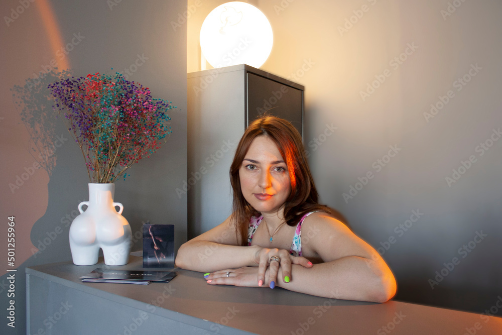 Young beautiful happy woman of European appearance in a dress against the background of a monochromatic gray wall Young beautiful happy woman of European appearance in a dress against the background of a monochromatic gray wall