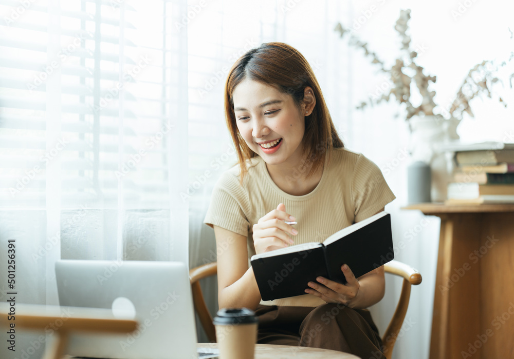 Portrait of Asian young female working on laptop and financial report at coffee shop. Portrait of Asian young female working on laptop and financial report at coffee shop.