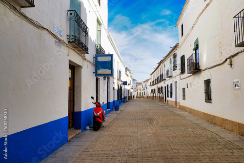 Typical street of a village of La Mancha with a red motorcycle © Jose