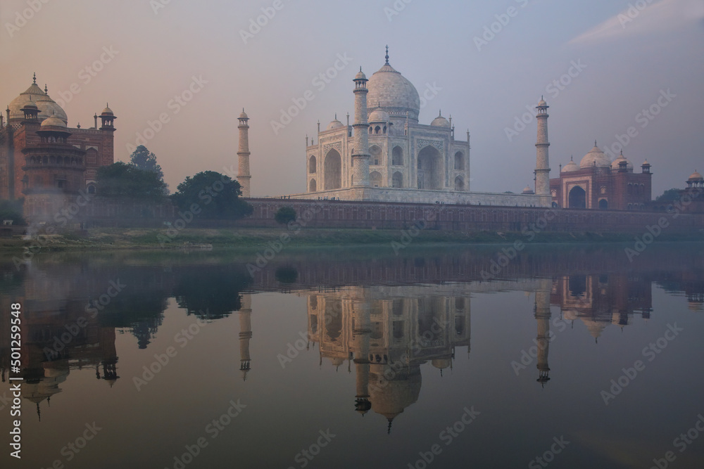 Fototapeta premium View of Taj Mahal with early morning fog reflected in Yamuna River, Agra, Uttar Pradesh, India