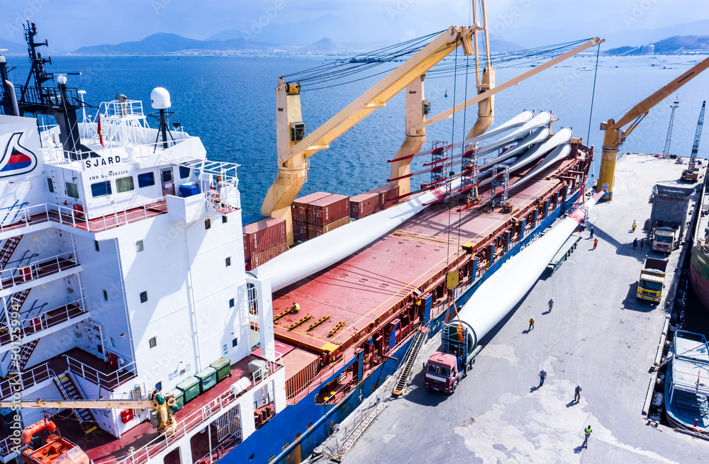 Container ship at industrial port in business logistic export import and  international water transportation. Containers and wind turbine parts in  cargo freight ship with industrial crane. Photos | Adobe Stock