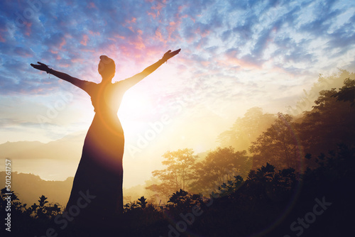 Woman successful hiking silhouette in mountains on sunset