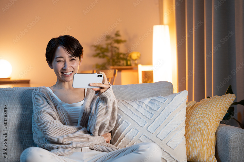 夜に家でリラックスする女性(スマホ・動画鑑賞・インターネット) 夜に家でリラックスする女性(スマホ・動画鑑賞・インターネット)