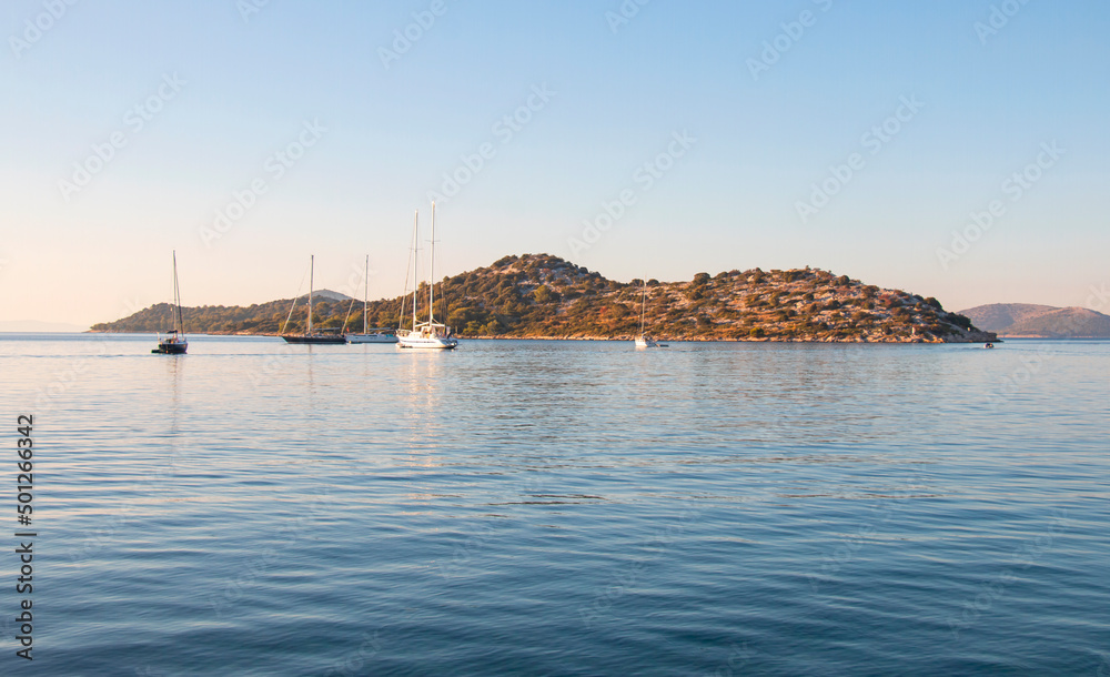 Beautiful turquoise sea at dawn, yachts laid up on a warm sunny morning. Seascape banner. Ideal place to relax