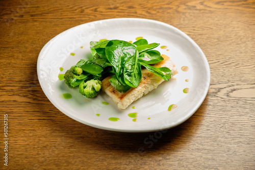 Pike perch fish fillet with spinach leaves