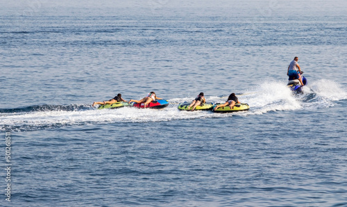 A row of women lying down, water skiing