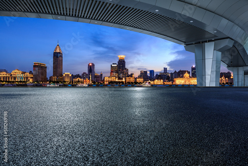 Asphalt road and city skyline with modern commercial buildings in Shanghai at night, China.