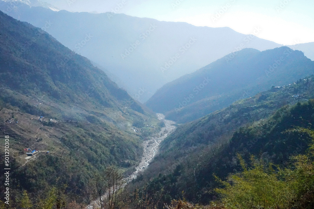 Natural landscape of rocky stream among green mountain valley hill