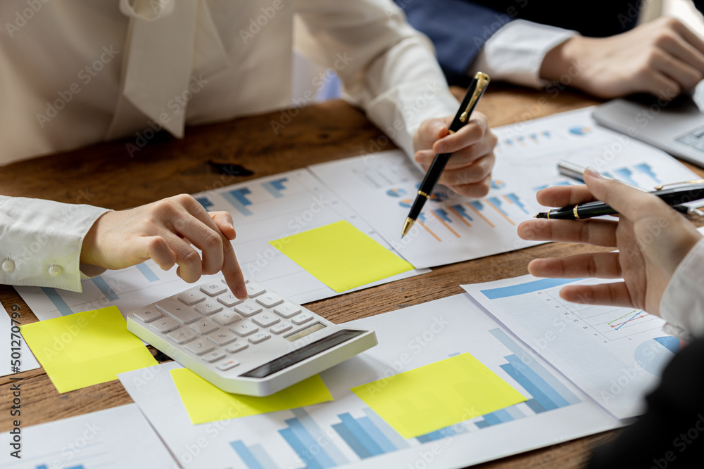 Fototapeta premium A desk in a company conference room has a group of business people attending and with supporting documents laid out, brainstorming sessions to fix and plan the company's growth. Business meeting idea.