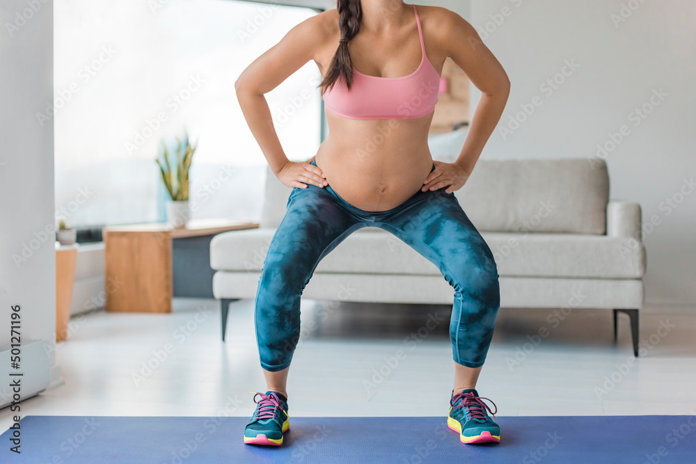 Home workout pregnant woman squatting doing leg workout squat with