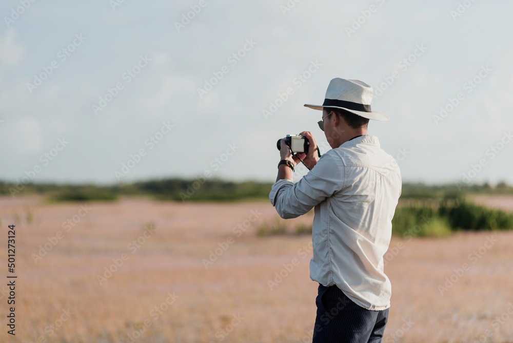 Asian tourist man looking at the scenery to take pictures with the camera. Asian tourist man looking at the scenery to take pictures with the camera.