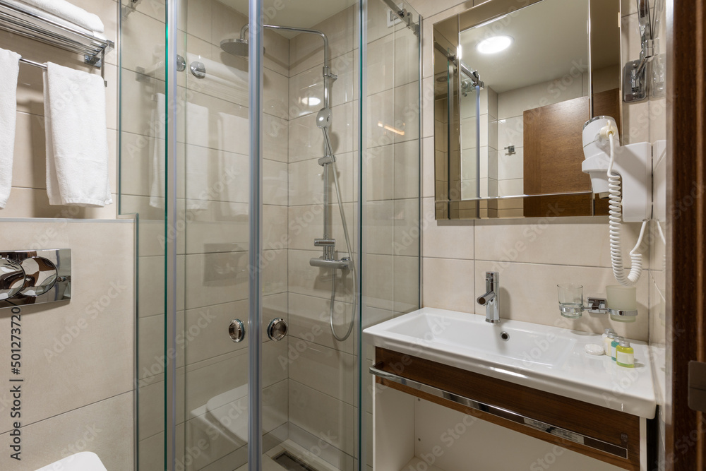 Interior of a hotel bathroom with glass shower cabin Interior of a hotel bathroom with glass shower cabin